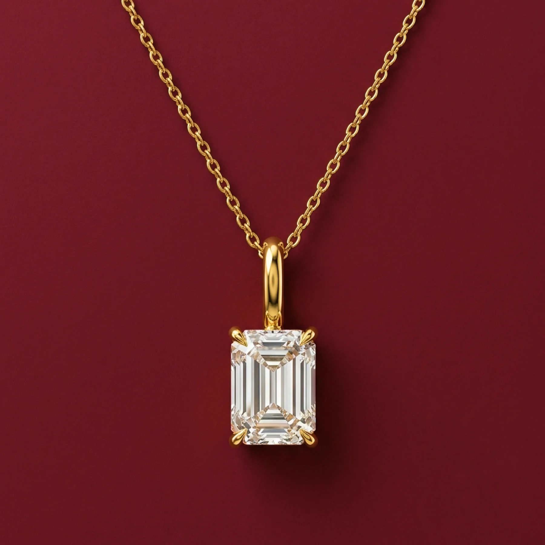 An emerald-cut diamond pendant on a warm-gold chain.