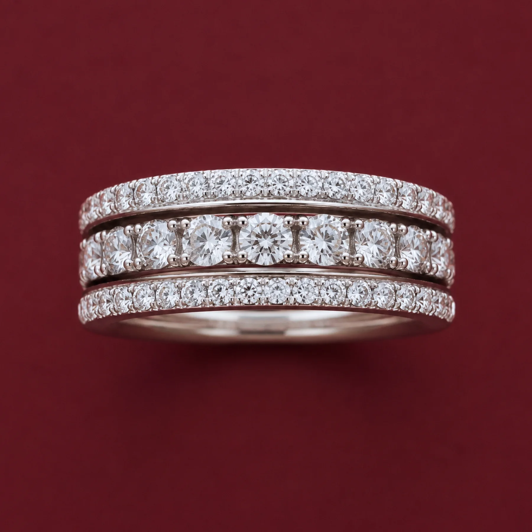 A stacked warm-gold companion band with diamonds on burgundy velvet.