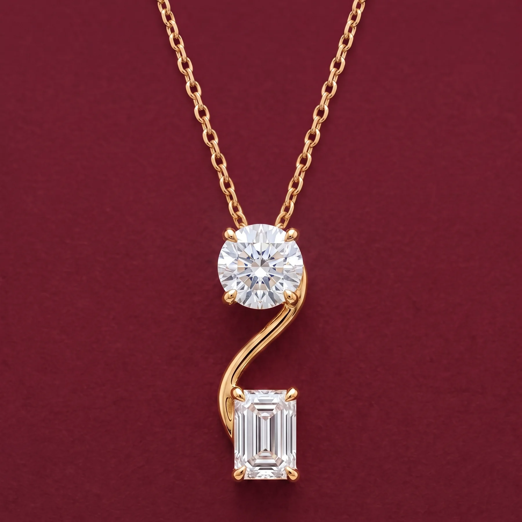 A warm-gold love pendant with round and emerald-cut diamonds.